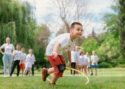 Kids enjoy outdoor fun with hula hoops in a vibrant park setting.
